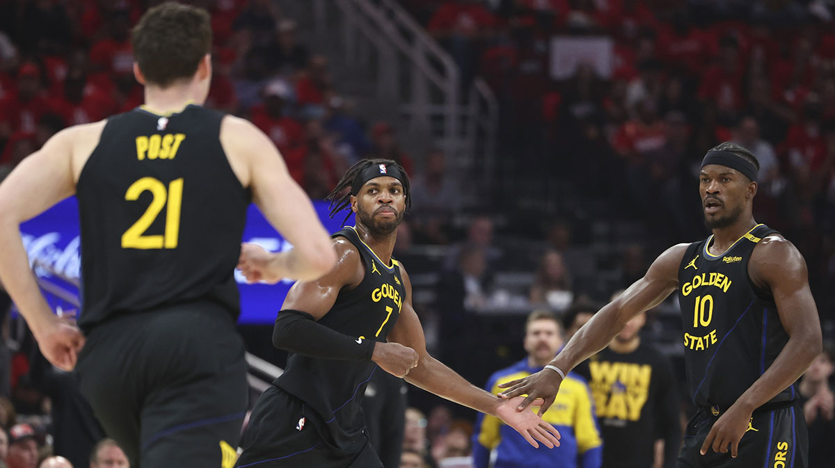 Warriors' Jimmy Butler high-fiving Buddy Hield as Quintin Post runs by.
