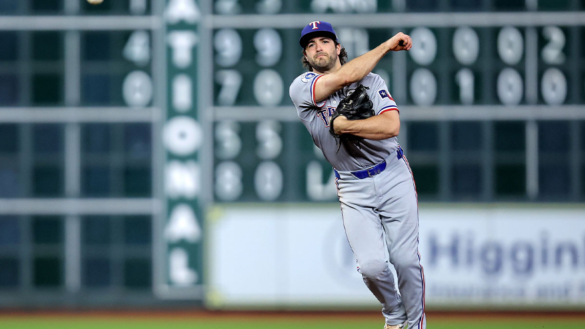 Texas Rangers third baseman Josh Smith (8) throws a fielded ball to first base for an out against the Houston Astros during the third inning at Daikin Park.