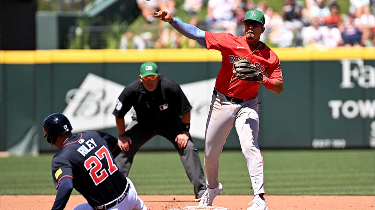 Atlanta Braves third baseman Austin Riley (27) slides as Boston Red Sox second baseman Vaughn Grissom (5) throws to first base in the fourth inning during spring training at CoolToday Park.