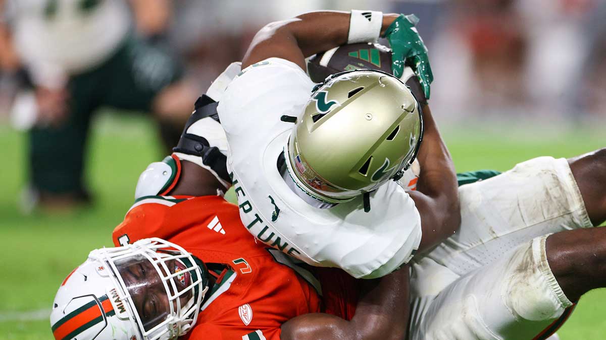 Miami Hurricanes defensive lineman Rueben Bain Jr. (4) tackles South Florida Bulls wide receiver Christian Neptune (81) in the third quarter at Hard Rock Stadium.
