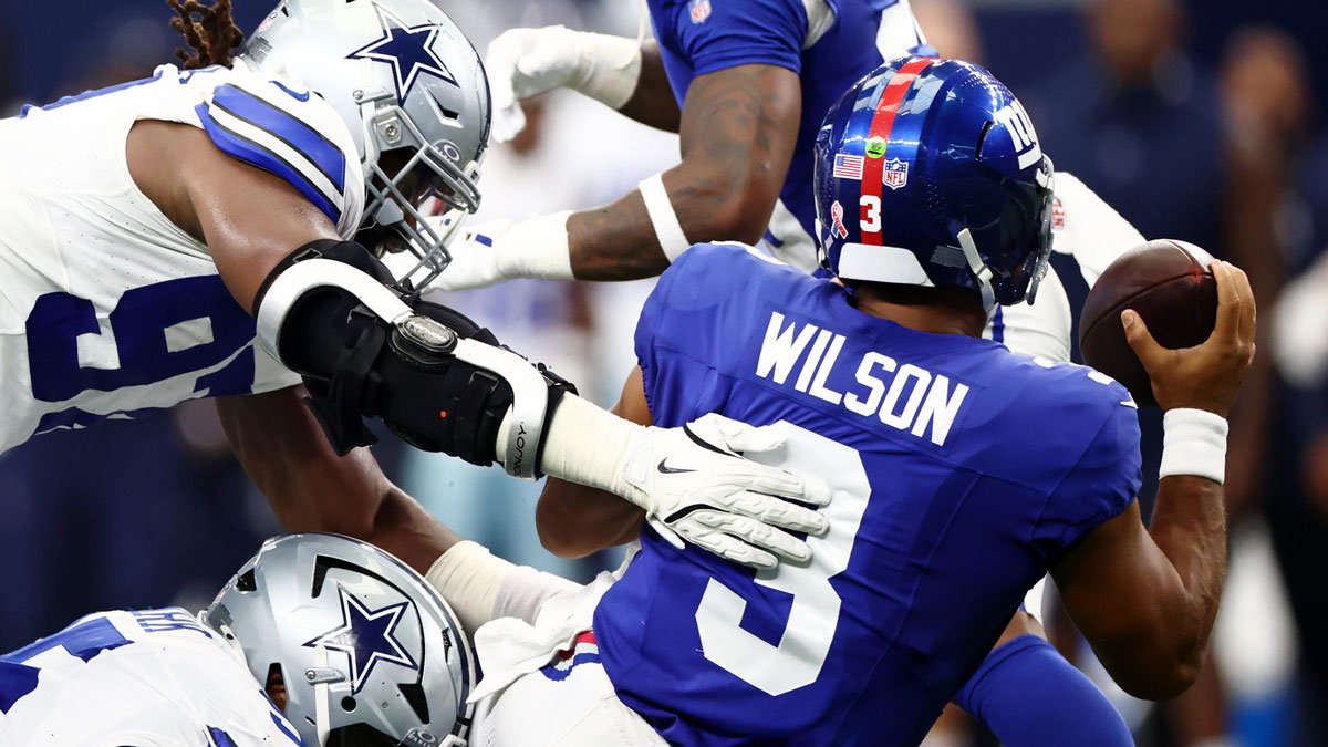 Dallas Cowboys defensive tackle Osa Odighizuwa (97) dives for New York Giants quarterback Russell Wilson (3) during the second quarter at AT&T Stadium.