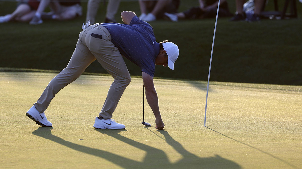 Mar 15, 2025; Ponte Vedra Beach, Florida, USA; Rory Mcllroy fixes a ball mark on the eighteenth green during the third round of The Players Championship golf tournament. Mandatory Credit: Jeff Swinger-Imagn Images
