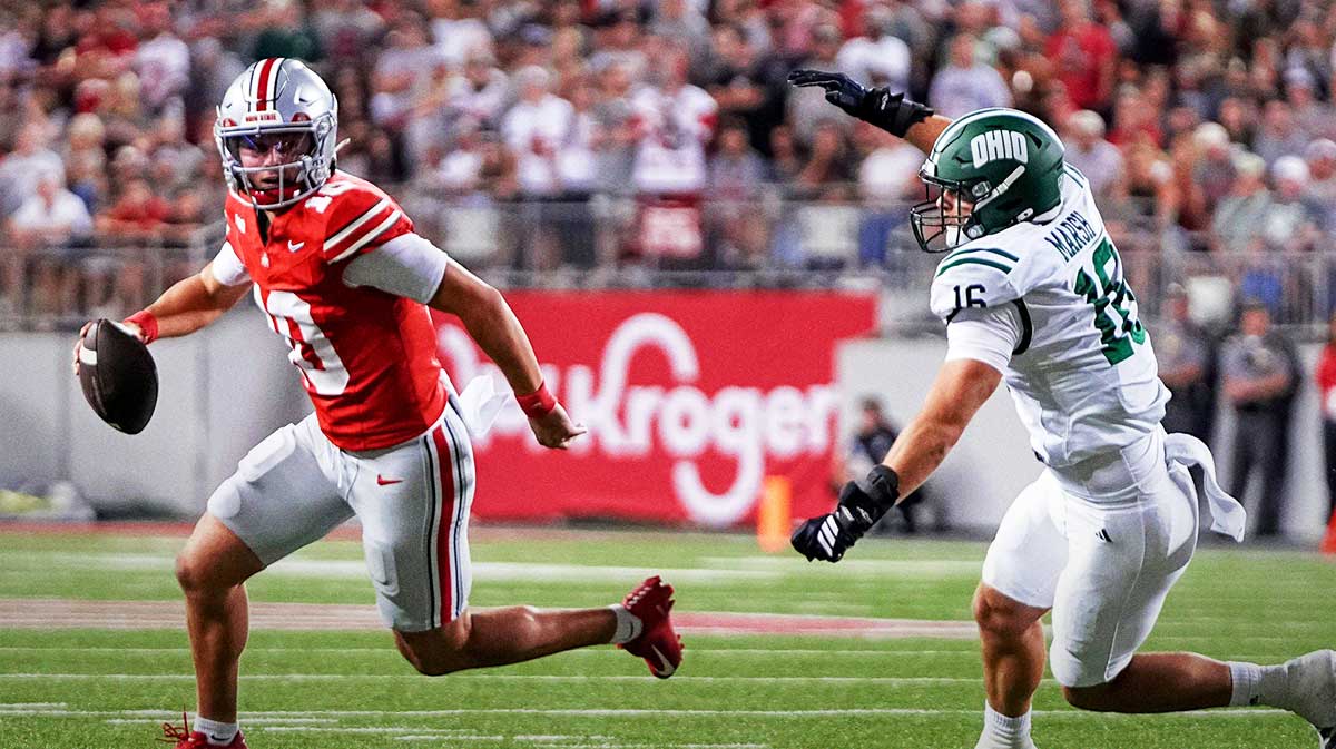 Ohio State Buckeyes quarterback Julian Sayin (10) runs away from Ohio Bobcats defensive end Joseph Marsh (16) during the NCAA football game at Ohio Stadium on Sept. 13, 2025. Ohio State won 37-9.