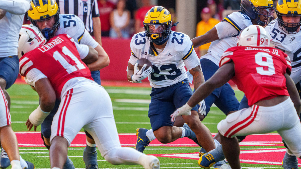 Michigan Wolverines running back Jordan Marshall (23) runs against Nebraska Cornhuskers linebacker Vincent Shavers Jr. (9) and defensive lineman Cameron Lenhardt (11) during the fourth quarter at Memorial Stadium.