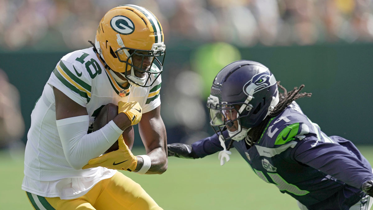 Green Bay Packers wide receiver Malik Heath (18) makes a catch before being tackles by Seattle Seahawks cornerback Shaquill Griffin (24) during the first quarter of their preseason game Saturday, August 23, 2025 at Lambeau Field in Green Bay, Wisconsin.