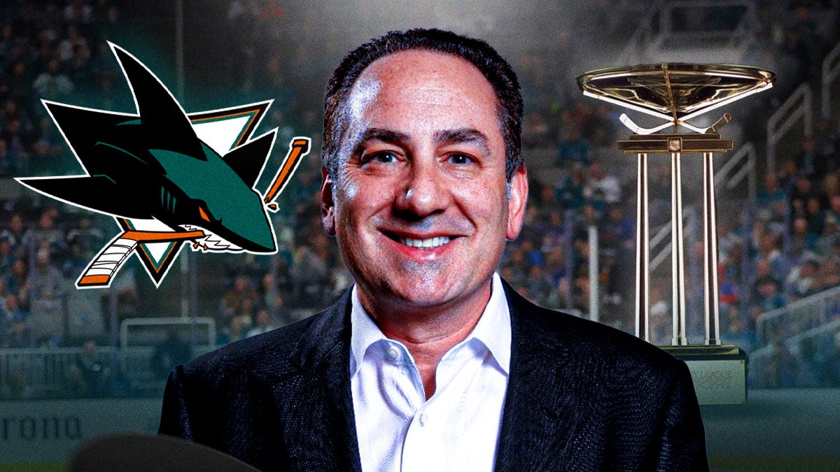 Sharks Team president Jonathan Becher with the President's Trophy and the Sharks logo in the background.
