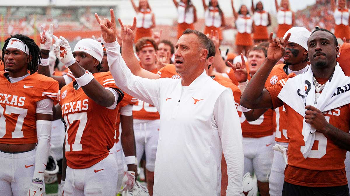 Texas Longhorns head coach Steve Sarkisian and players hold up their horns with the fans during the singing of the Eyes of Texas after a victory over the San Jose State Spartans at Darrell K Royal-Texas Memorial Stadium.