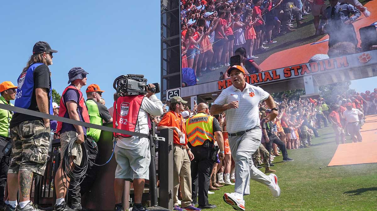 Clemson Tigers head coach Dabo Swinney runs down the hill before in Memorial Stadium before the game against the Syracuse Orange.