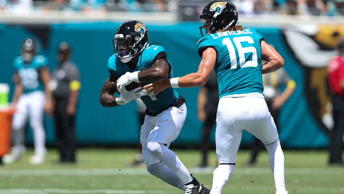 Jacksonville Jaguars quarterback Trevor Lawrence (16) hands off to running back Tank Bigsby (4) against the Carolina Panthers during the first half at EverBank Stadium.