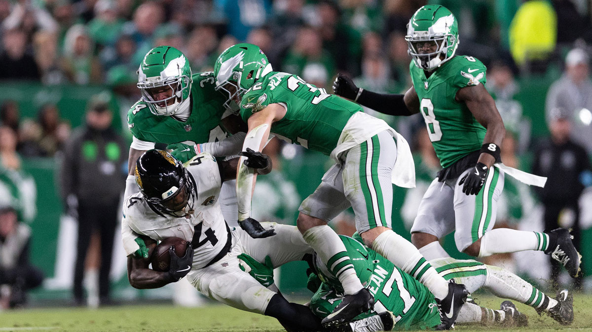 Jacksonville Jaguars running back Tank Bigsby (4) is tackled by Philadelphia Eagles linebacker Nakobe Dean (17) and cornerback Isaiah Rodgers (34) during the fourth quarter at Lincoln Financial Field.