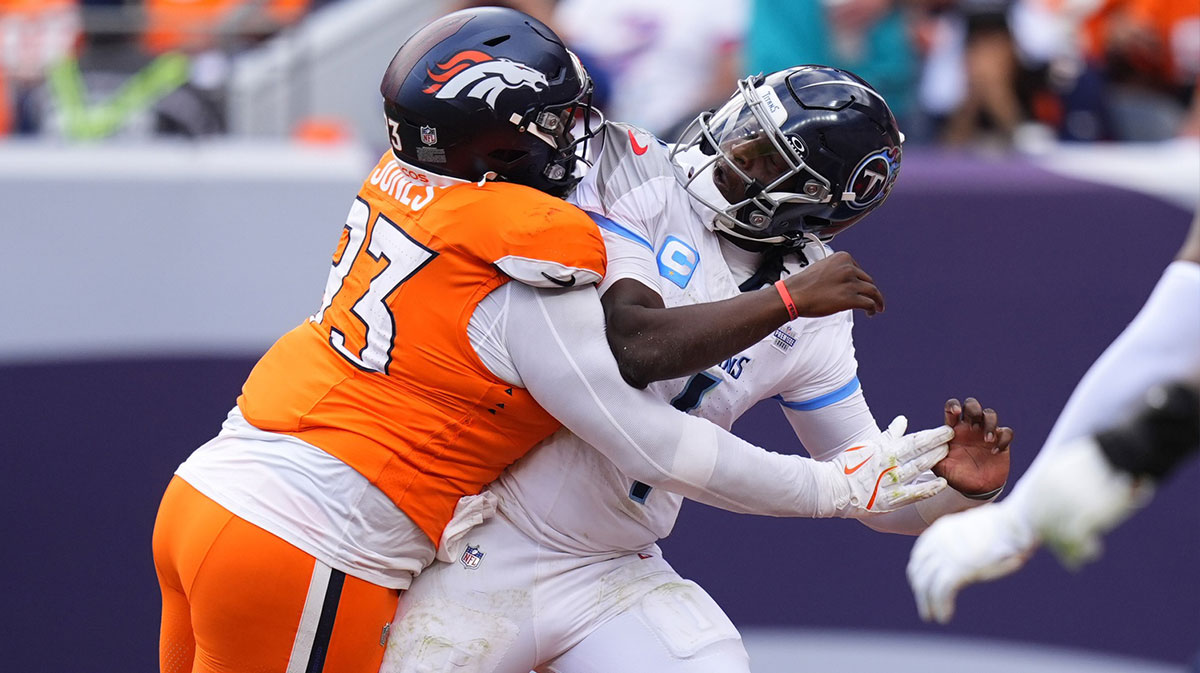 Denver Broncos defensive tackle D.J. Jones (93) hits Tennessee Titans quarterback Cam Ward (1) in the second half at Empower Field at Mile High.