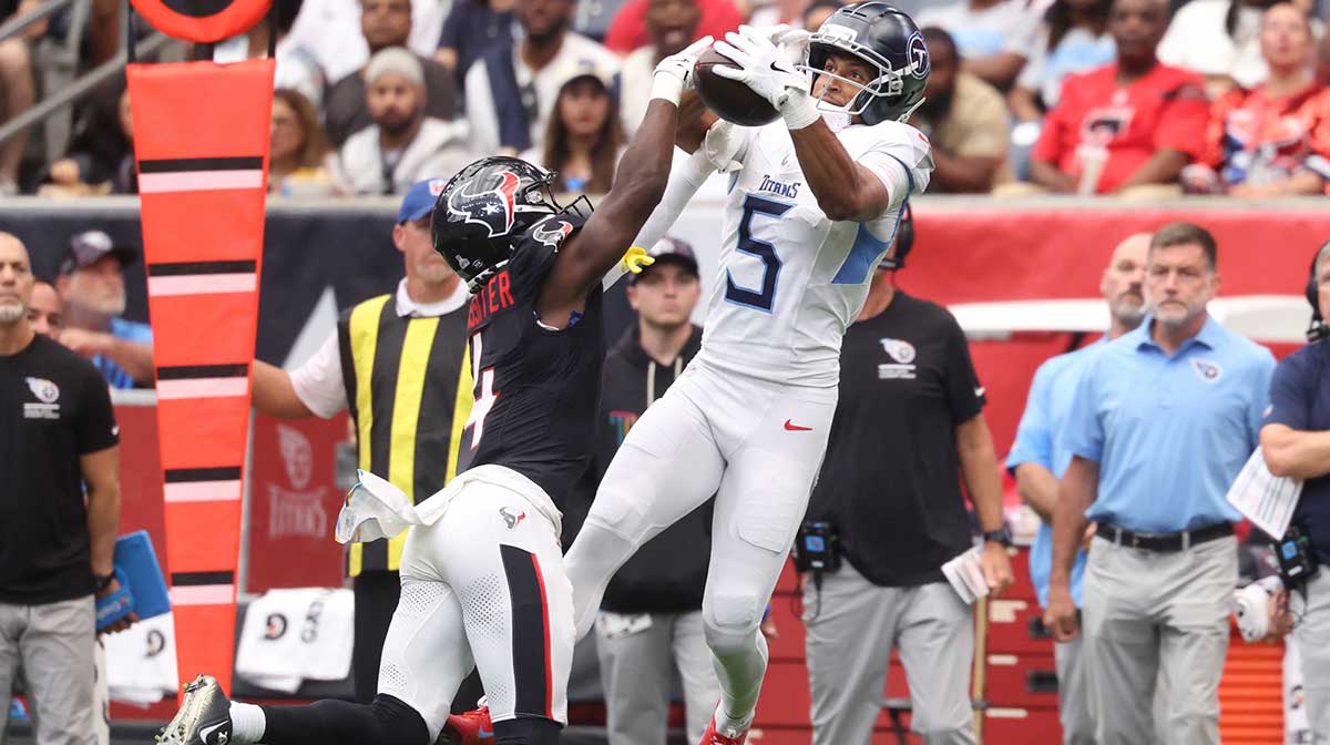 Tennessee Titans wide receiver Elic Ayomanor (5) makes a catch against Houston Texans cornerback Kamari Lassiter (4) during the first half at NRG Stadium.