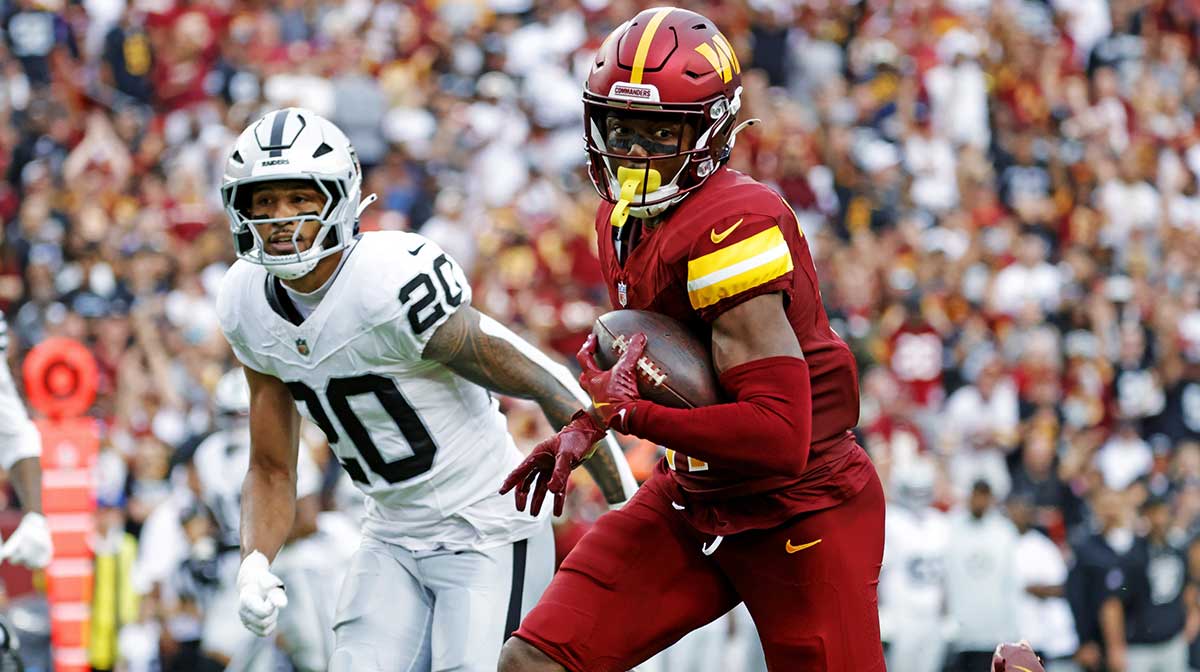 Washington Commanders wide receiver Terry McLaurin (17) runs the ball during the second half as Las Vegas Raiders safety Isaiah Pola-Mao (20) defends at Northwest Stadium.
