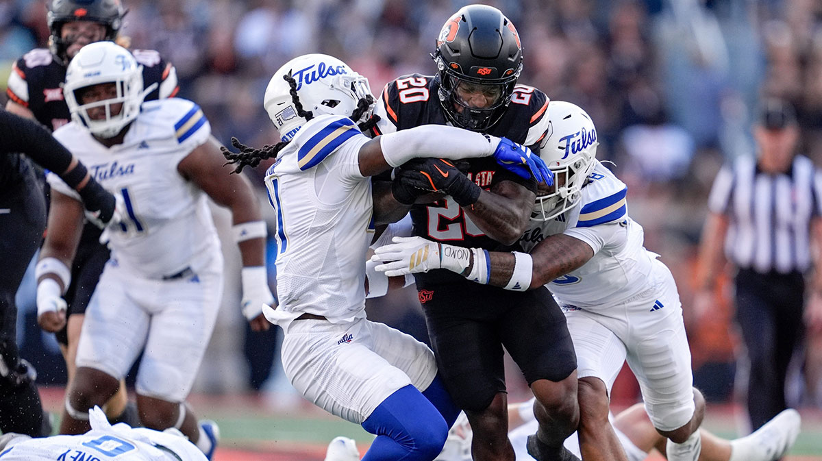 Oklahoma State running back Rodney Fields Jr. (20) runs the ball and is taken down by Tulsa safety Lento Smith Jr. (21) and Tulsa safety Zach Williams (18) in the first quarter during an NCAA football game between Oklahoma State (OSU) and Tulsa at Boone Pickens Stadium in Stillwater, Okla., on Friday, Sept. 19, 2025.