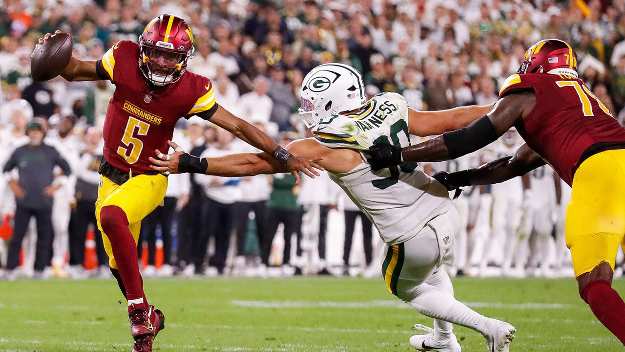 Washington Commanders quarterback Jayden Daniels (5) scrambles away from Green Bay Packers defensive end Lukas Van Ness (90) on Thursday, September 11, 2025, at Lambeau Field in Green Bay, Wis. The Packers won the game, 27-18.