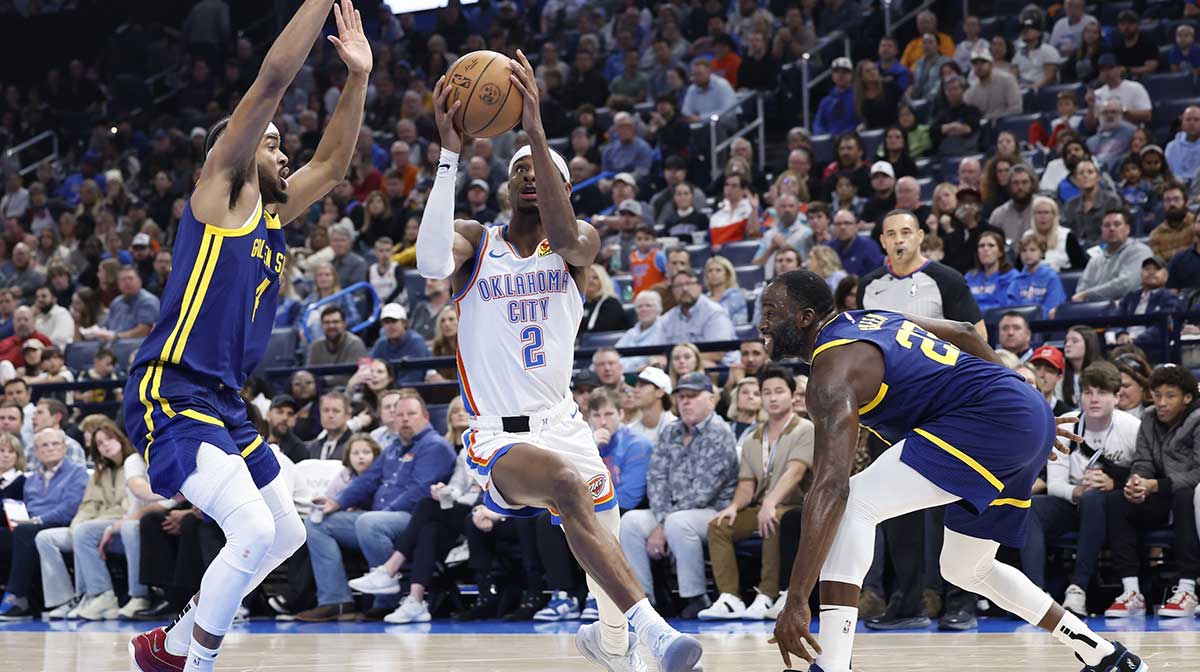 Thunder guard Shai Gilgeous-Alexander (2) moves to the basket against Golden State Warriors guard Moses Moody (4) and forward Draymond Green (23) during the second quarter at Paycom Center