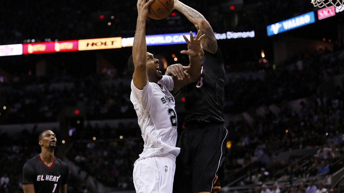 San Antonio Spurs forward Tim Duncan (left) shoots the ball as Miami Heat forward Michael Beasley (right) defends during the second half at AT&T Center. The Spurs won 111-87.