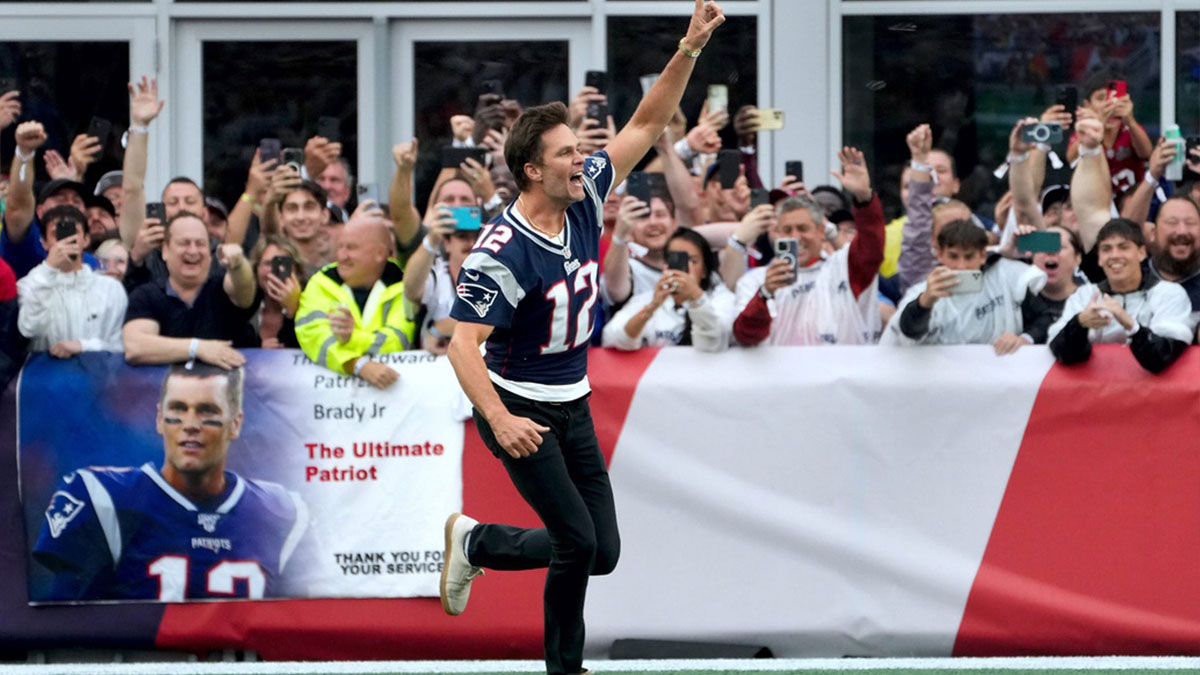 Former New England Patriots quarterback, Tom Brady, runs on to the field at Gillette Stadium on Sunday evening to welcome fans as the Patriots announce they will induct him into the Patriots Hall of Fame in June.