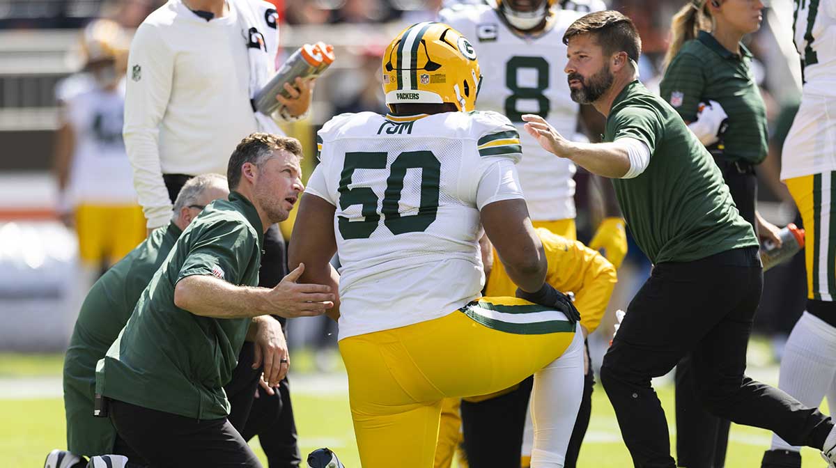 Green Bay Packers offensive tackle Zach Tom (50) is attended to by medical personnel for an on field injury during the first quarter against the Cleveland Browns at Huntington Bank Field.