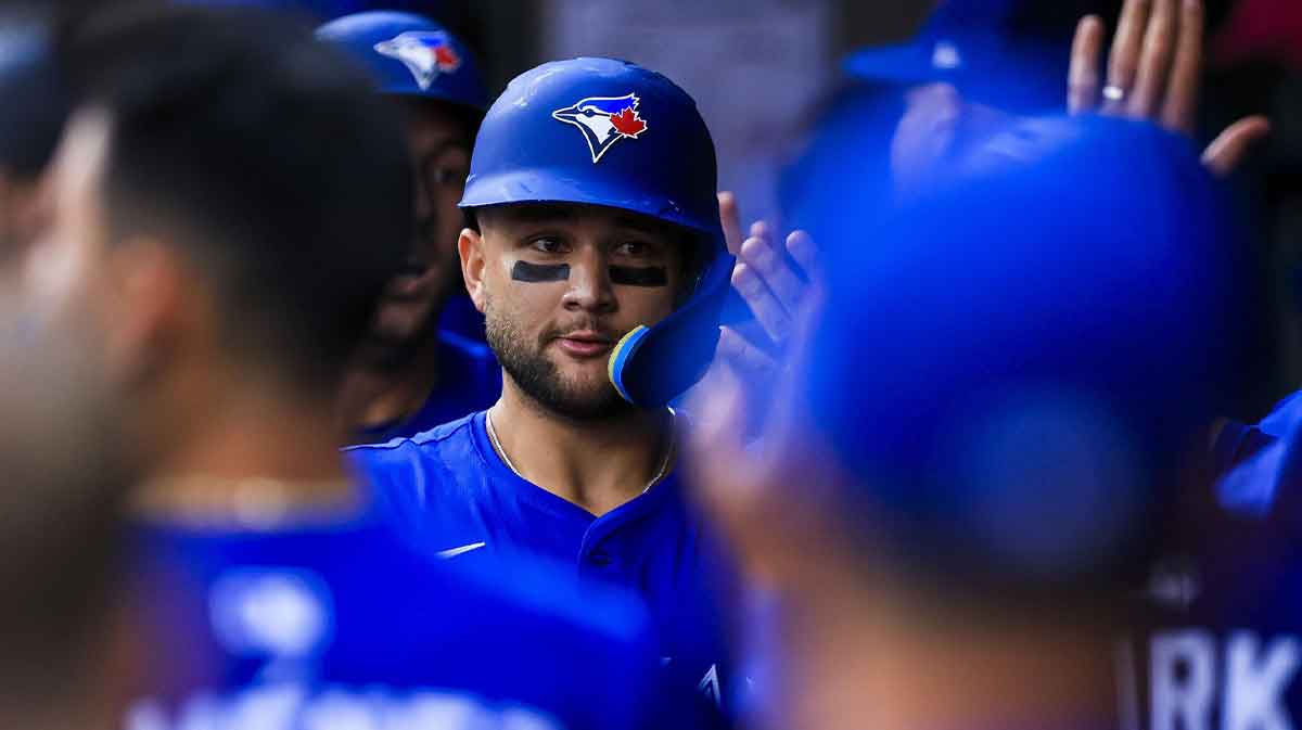 Toronto Blue Jays shortstop Bo Bichette (11) high fives teammates after hitting a three-run home run in the second inning against the Cincinnati Reds at Great American Ball Park.