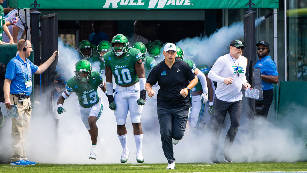 Tulane Green Wave head coach Jon Sumrall runs out the tunnel with defensive end Gerrod Henderson (10) and safety Tavare Smith (13) against Northwestern Wildcats during the first half at Yulman Stadium.