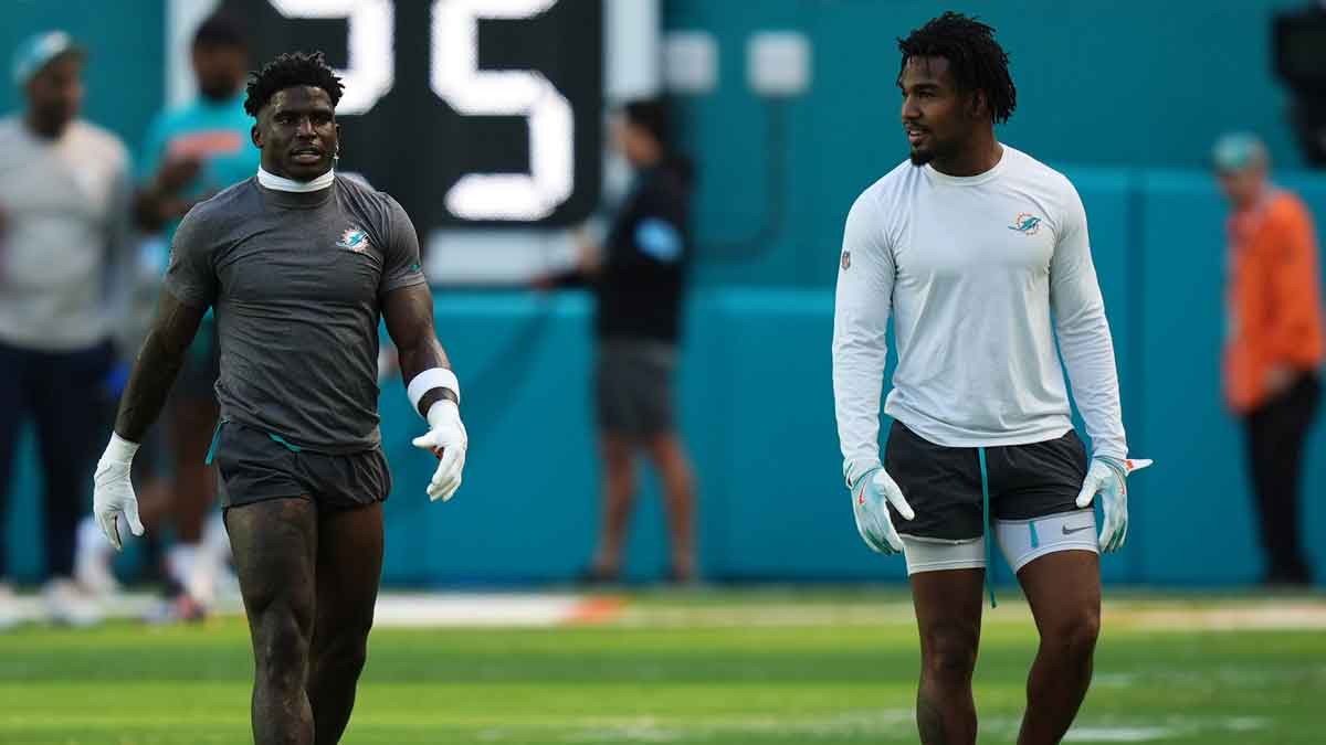 Miami Dolphins wide receiver Tyreek Hill (L) and Miami Dolphins wide receiver Jaylen Waddle (R) walk on the field prior to the game against the New England Patriots at Hard Rock Stadium
