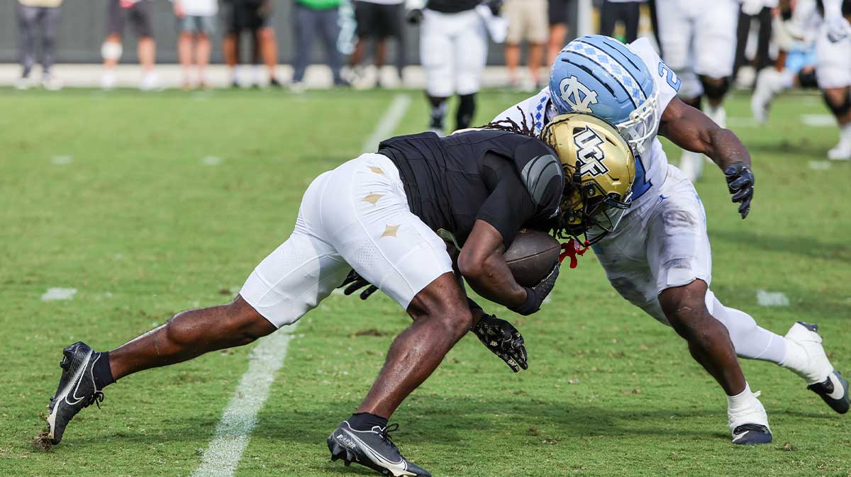 UCF Knights wide receiver Duane Thomas Jr. (7) is tackled by North Carolina Tar Heels defensive back Kaleb Cost (21) during the second quarter at the Bounce House Stadium.