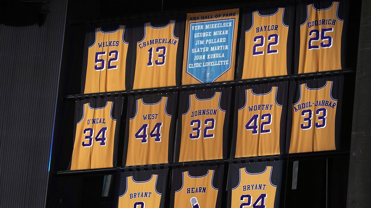 The retired jerseys of Los Angeles Lakers players Jamaal Wilkes (52), Wilt Chamberlain (13), Elgin Baylor (22), Shaquille O'Neal (34), Jerry West (44), Magic Johnson (32), James Worthy (42), Kareem Abdul-Jabbar (33), Kobe Bryant (8 and 24) and Chick Hearn and the names of Minneapolis Lakers Hall of Fame players Vern Mikkelsen, George Mikan, Jim Pollard, Slater Martin, John Kundla and Clyde Lovellette on display at Staples Center.