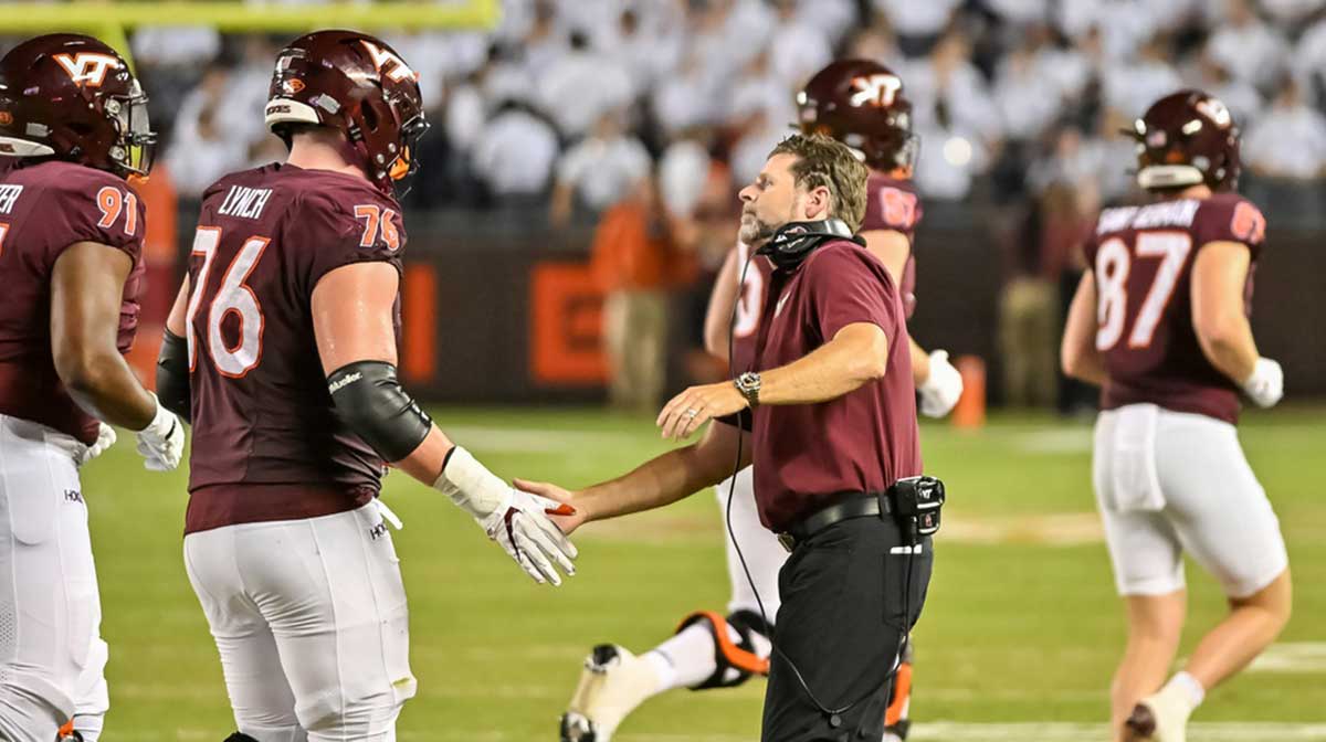 Virginia Tech Hokies head coach Brent Pry celebrates a score with Virginia Tech Hokies offensive lineman Aidan Lynch (76) during the fourth quarter at Lane Stadium.