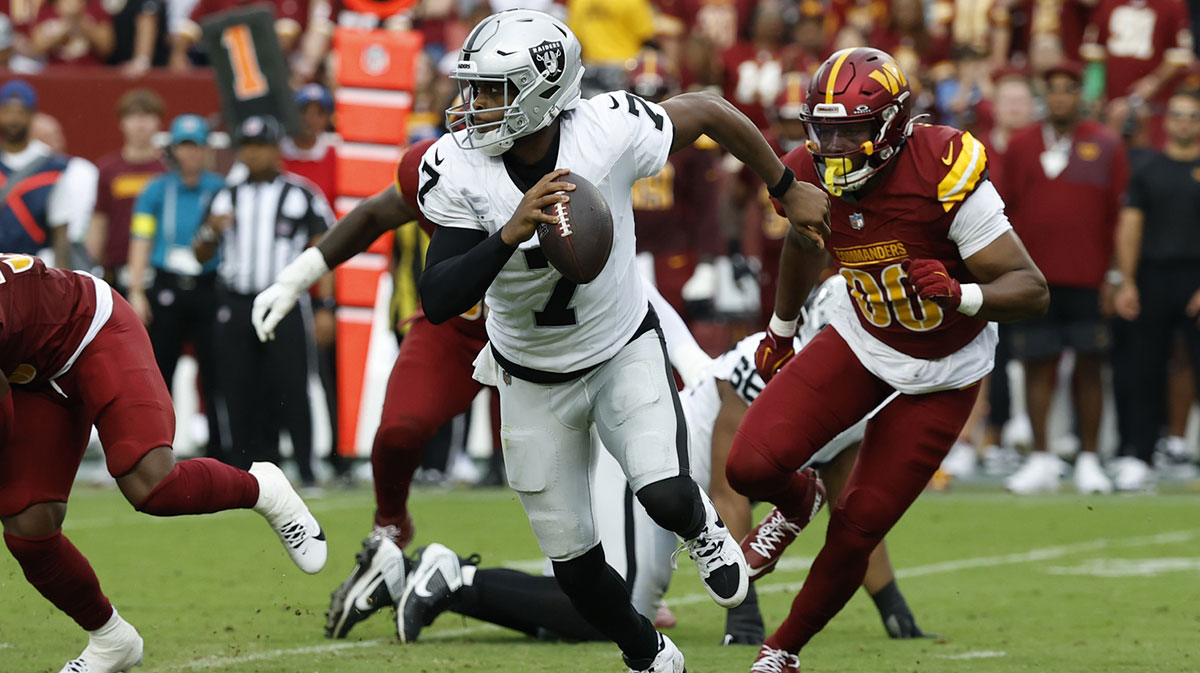 Las Vegas Raiders quarterback Geno Smith (7) scrambles from Washington Commanders defensive end Javontae Jean-Baptiste (90) during the third quarter at Northwest Stadium.