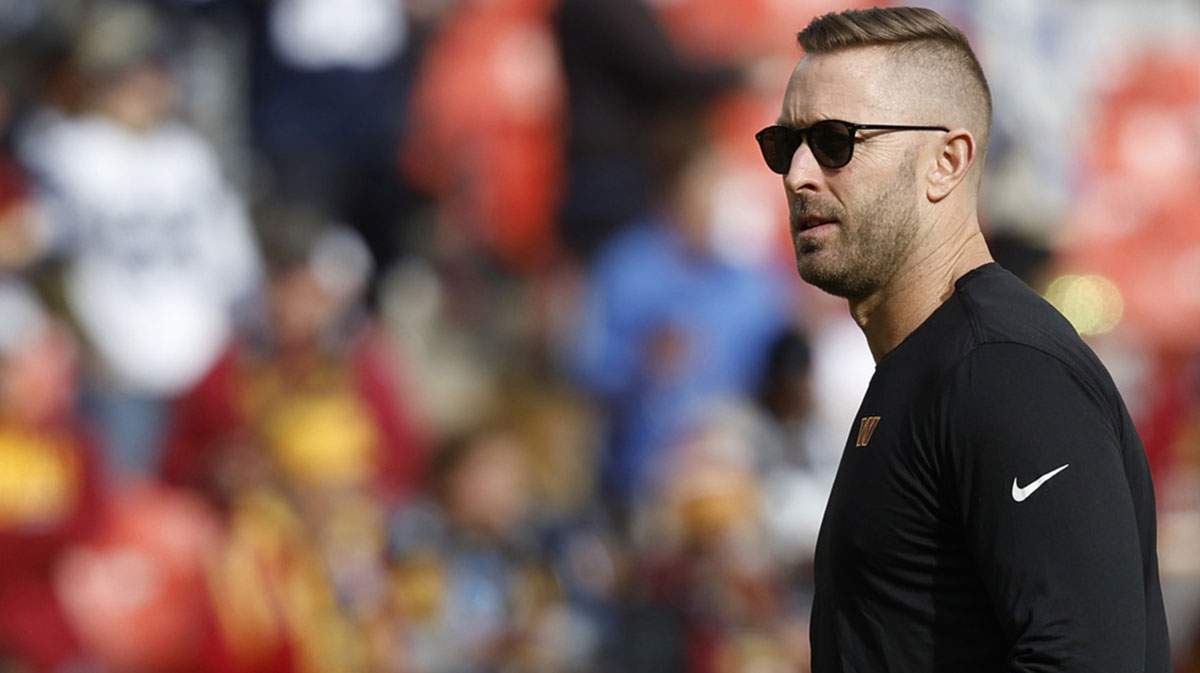 Washington Commanders offensive coordinator Kliff Kingsbury stands on the field during warmup prior to the game against the Dallas Cowboys at Northwest Stadium.