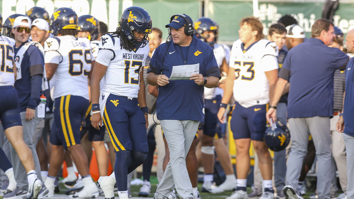 West Virginia Mountaineers head coach Rich Rodriguez talks with West Virginia Mountaineers quarterback Jaylen Henderson (13) during the fourth quarter against the Ohio Bobcats at Peden Stadium.