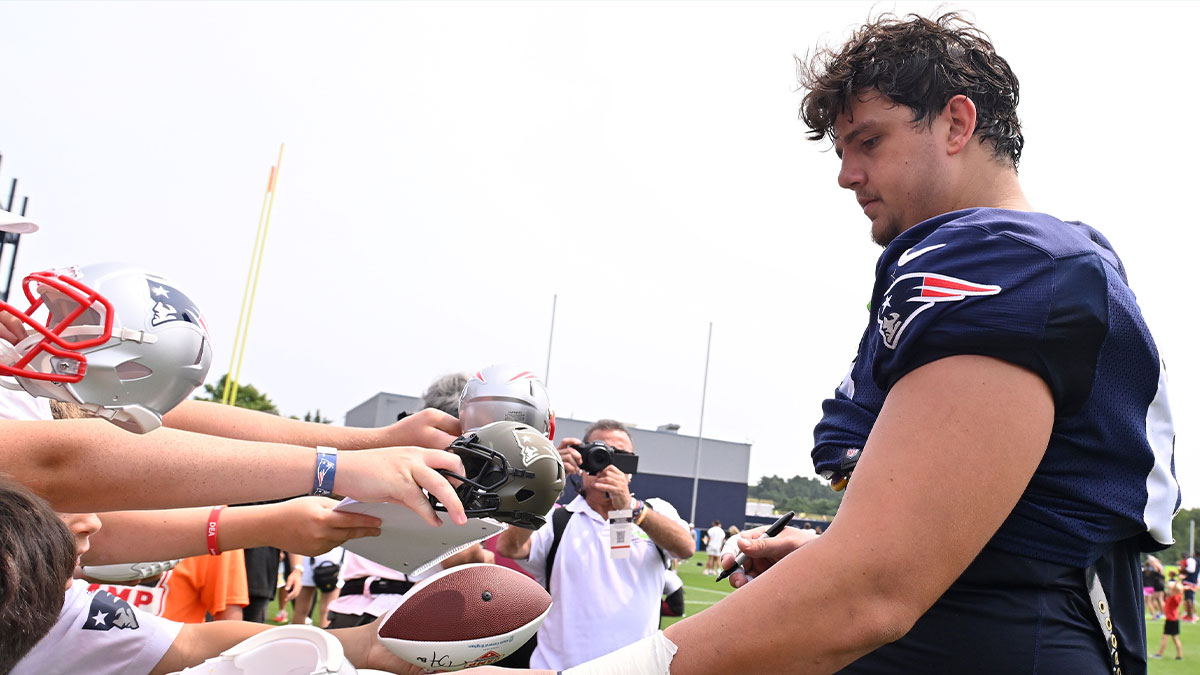 New England Patriots offensive tackle Will Campbell (66) signs autographs after training camp at Gillette Stadium.