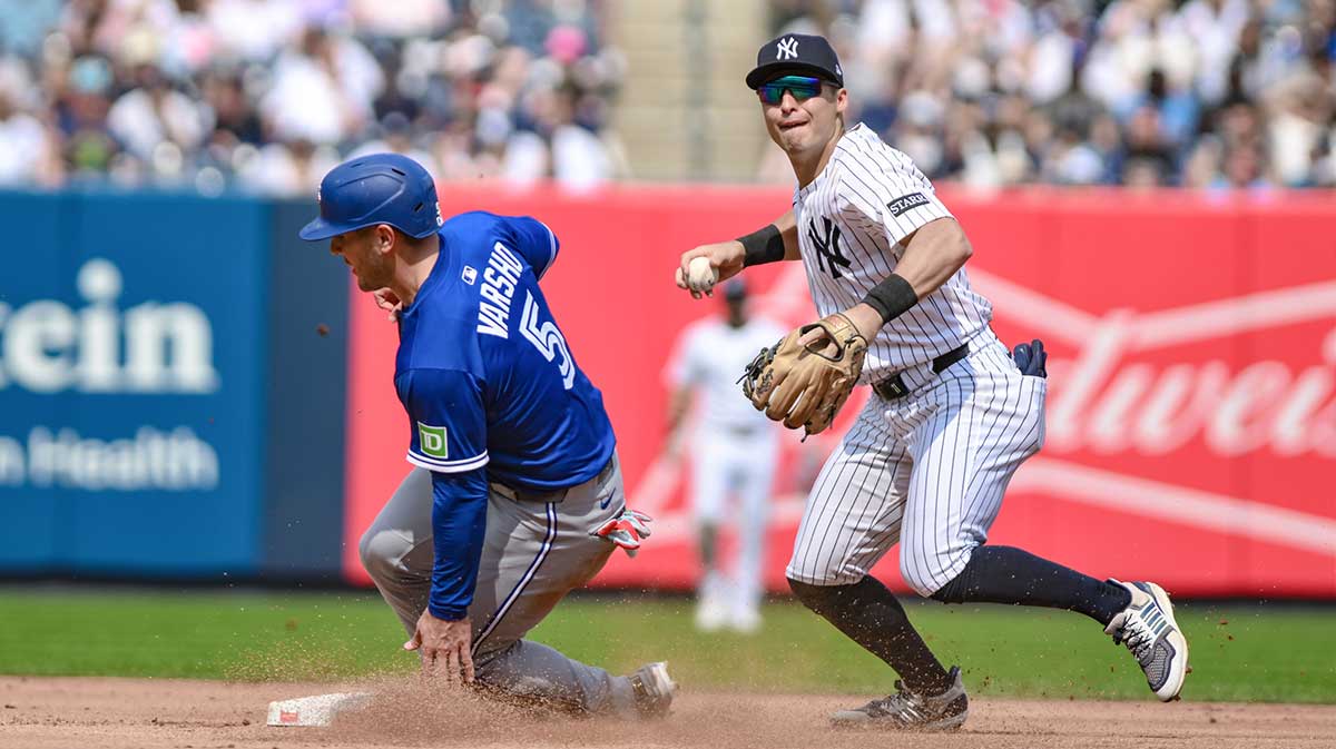 New York Yankees shortstop Anthony Volpe (11) forces out Toronto Blue Jays outfielder Daulton Varsho (5) at second base but cannot complete the double play during the fourth inning at Yankee Stadium.