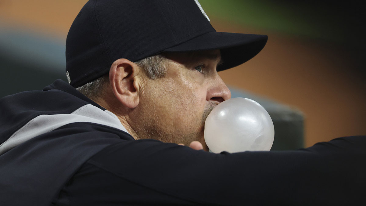 New York Yankees manager Aaron Boone blows a bubble in the dugout during the second inning against the Houston Astros at Daikin Park.
