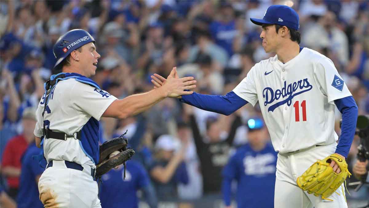 Los Angeles Dodgers catcher Will Smith (16) and pitcher Roki Sasaki (11) celebrate after defeating the Milwaukee Brewers in game three of the NLCS round for the 2025 MLB playoffs at Dodger Stadium.