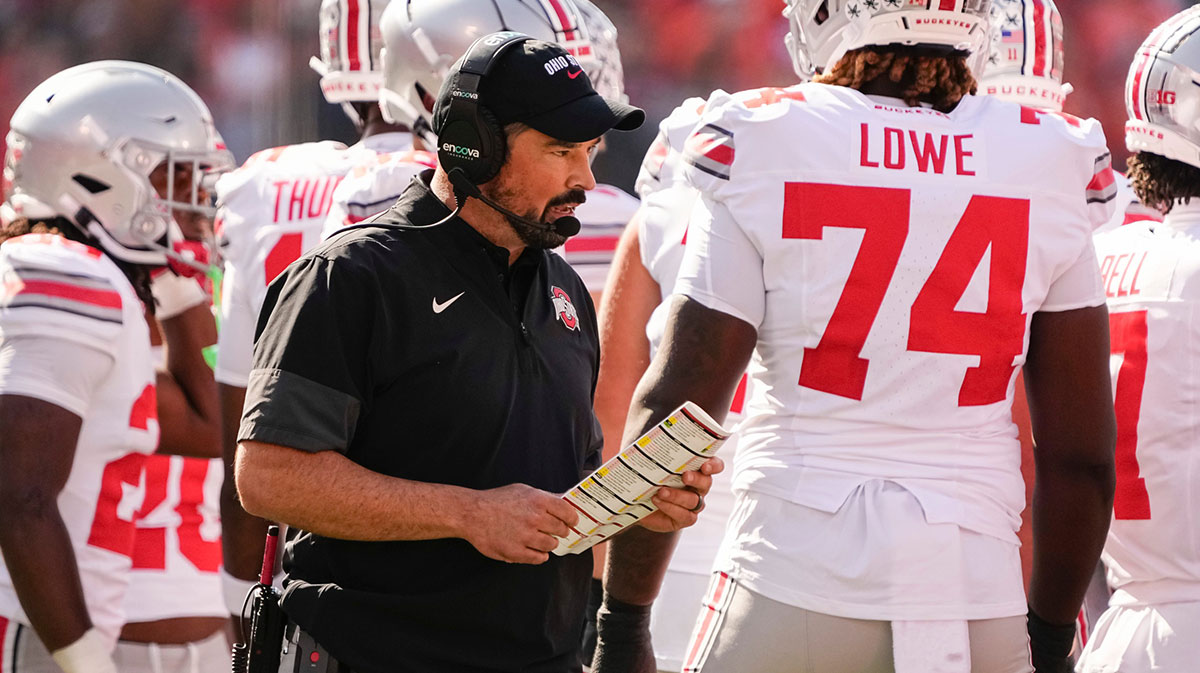 Ohio State Buckeyes head coach Ryan Day talks to players on the sideline during a timeout in the first half of the NCAA football game against the Illinois Fighting Illini at Gies Memorial Stadium in Champaign on Oct. 11, 2025.