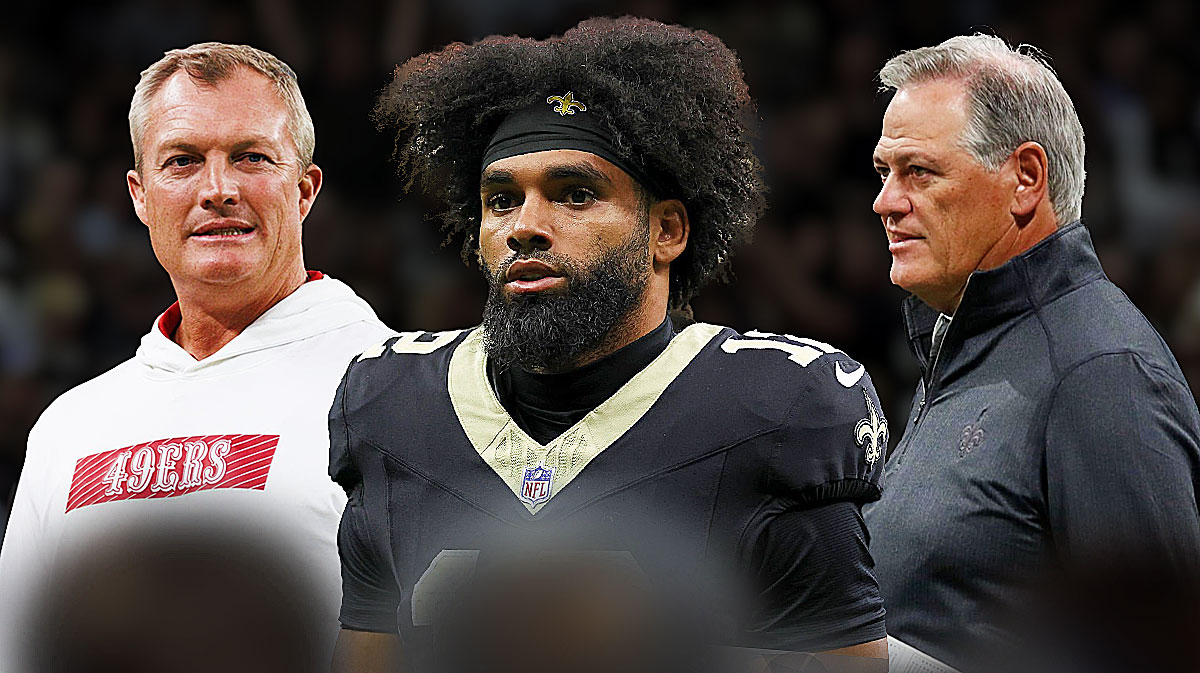 Saints WR Chris Olave (center) with 49ers GM John Lynch and Saints GM Mickey Loomis behind him