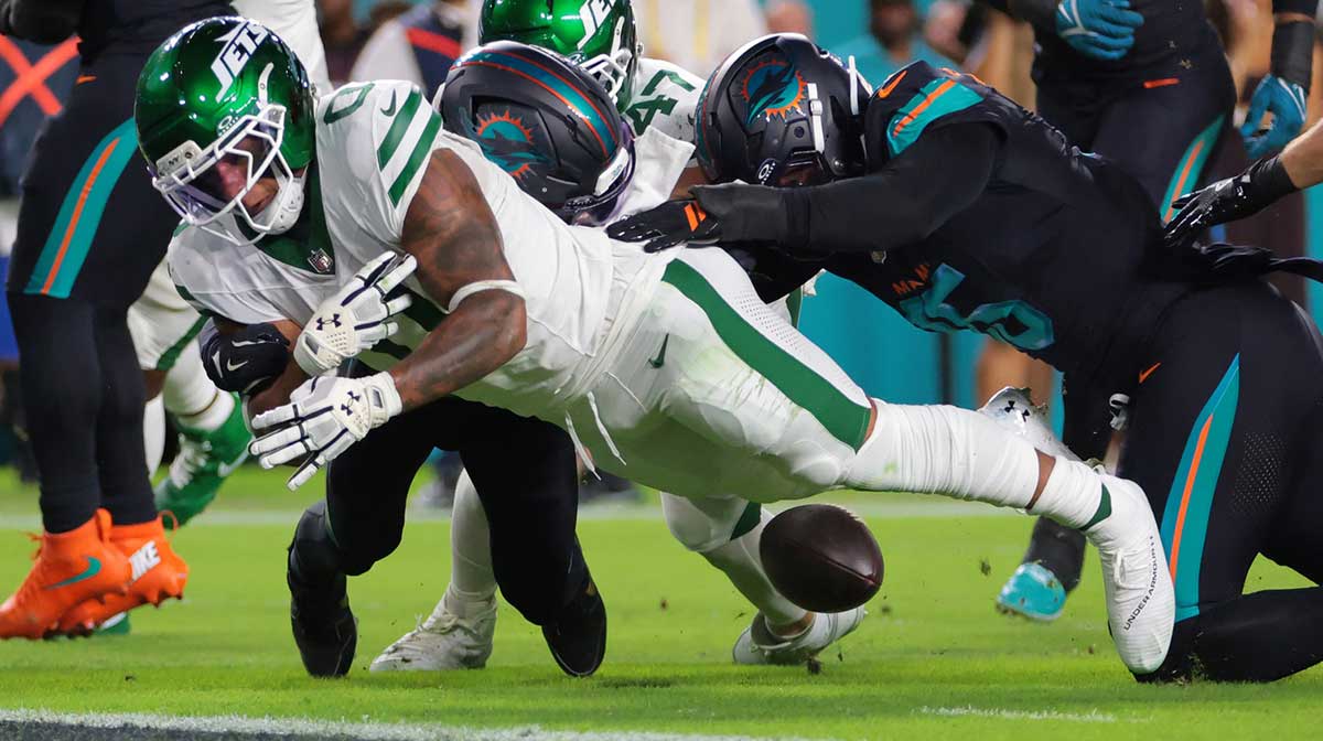New York Jets running back Braelon Allen (0) fumbles the ball against Miami Dolphins defensive back Elijah Campbell (22) during the first half at Hard Rock Stadium.