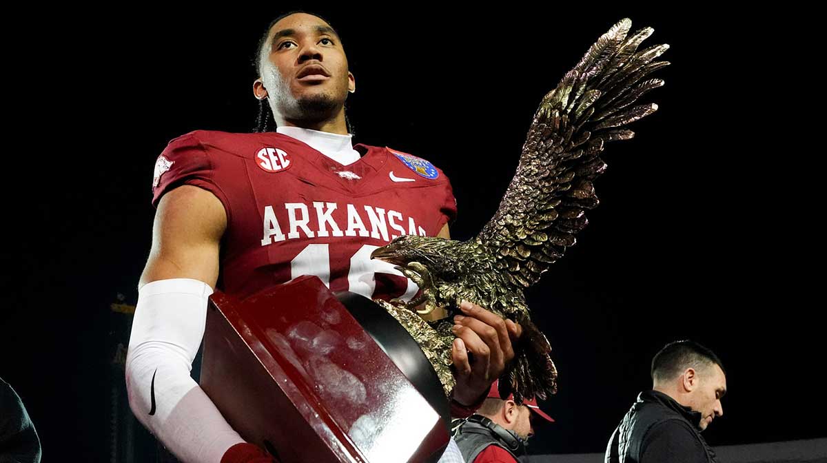 Arkansas’ Taylen Green (10) holds up his MVP trophy after Arkansas defeated Texas Tech 36-26 in the AutoZone Liberty Bowl in Memphis, Tenn., on Friday, December 27, 2024.