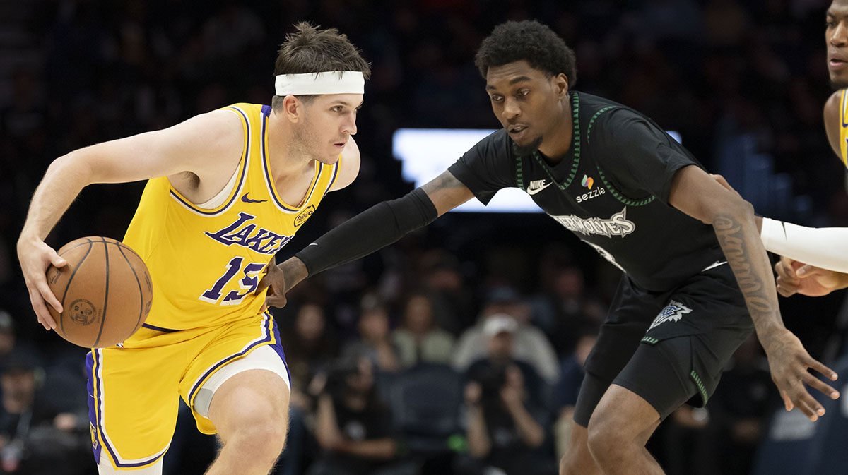 Los Angeles Lakers guard Austin Reaves (15) dribbles the ball past Minnesota Timberwolves forward Jaden McDaniels (3) in the second half at Target Center.