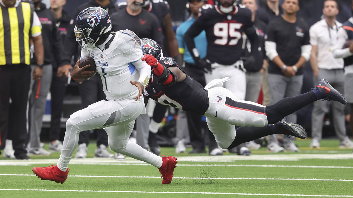 Tennessee Titans quarterback Cam Ward (1) runs with the ball as at Houston Texans linebacker Azeez Al-Shaair (0) attempts to make a tackle during the fourth quarter NRG Stadium.