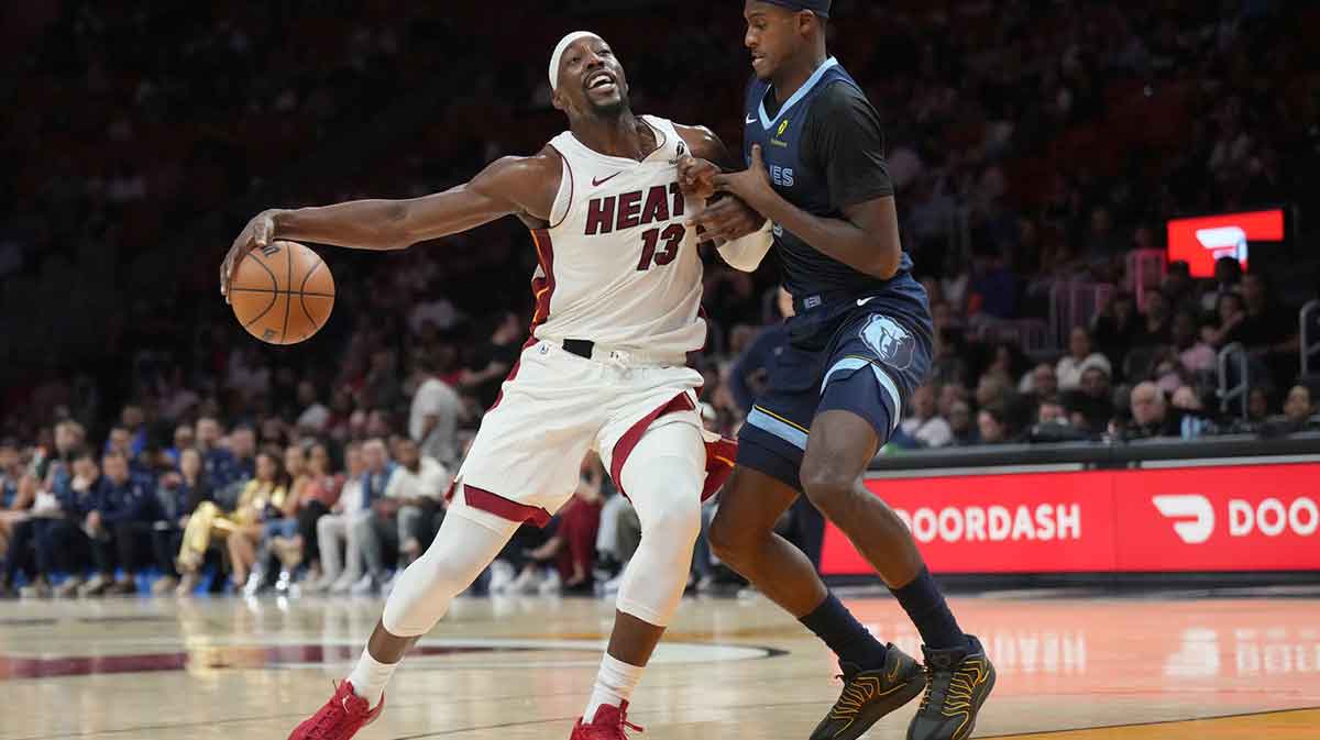Memphis Grizzlies forward Olivier-Maxence Prosper (18) collides with Miami Heat center Bam Adebayo (13) during the first half at Kaseya Center.
