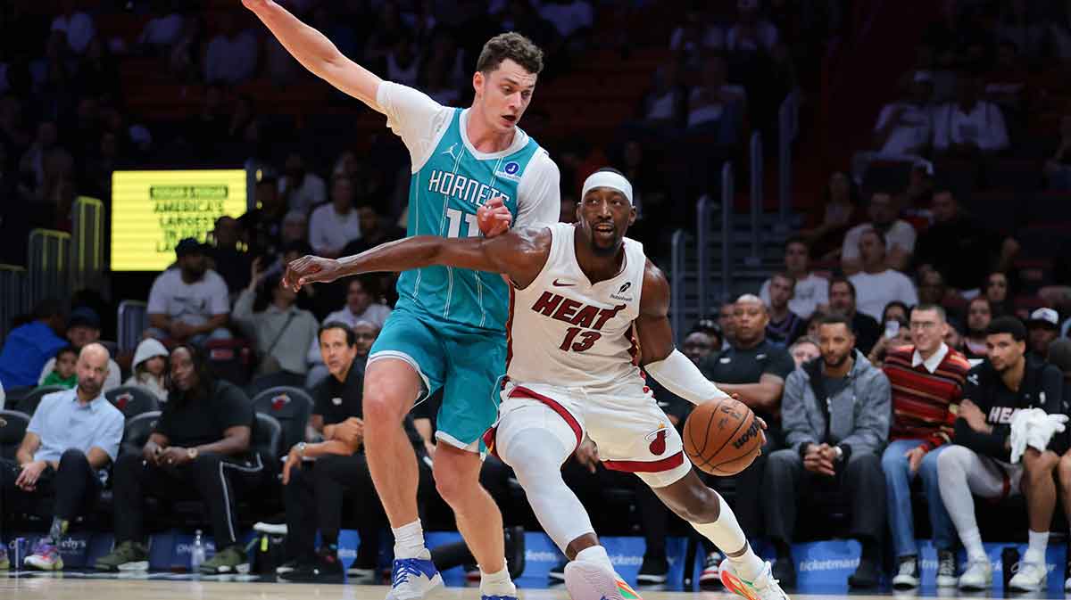 Miami Heat center Bam Adebayo (13) drives to the basket against Charlotte Hornets center Ryan Kalkbrenner (11) during the fourth quarter at Kaseya Center.