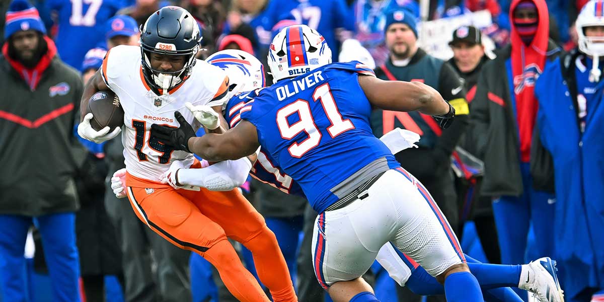 Denver Broncos wide receiver Marvin Mims Jr. (19) is tackled by Buffalo Bills defensive tackle Ed Oliver (91) and cornerback Christian Benford (47) in the fourth quarter of an AFC wild card game at Highmark Stadium.