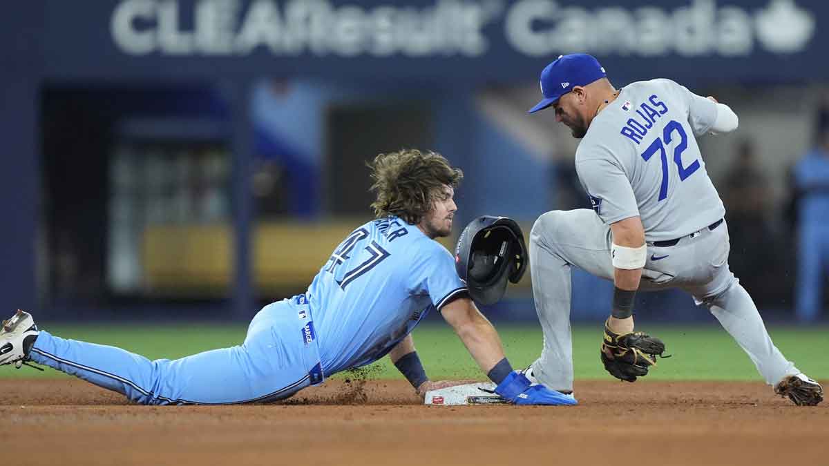 Los Angeles Dodgers second baseman Miguel Rojas (72) makes a double play against Toronto Blue Jays third baseman Addison Barger (47) in the ninth inning during game six of the 2025 MLB World Series at Rogers Centre.