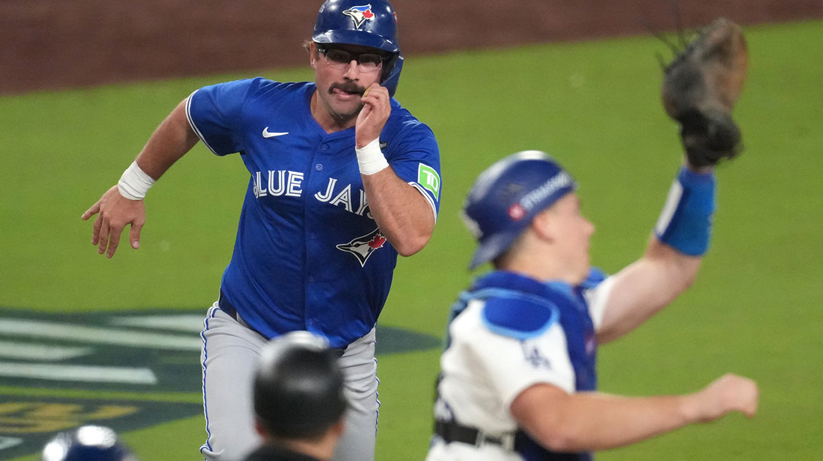 Toronto Blue Jays left fielder Davis Schneider (36) is out at home against Los Angeles Dodgers catcher Will Smith (16) in the tenth inning during game three of the 2025 MLB World Series at Dodger Stadium.