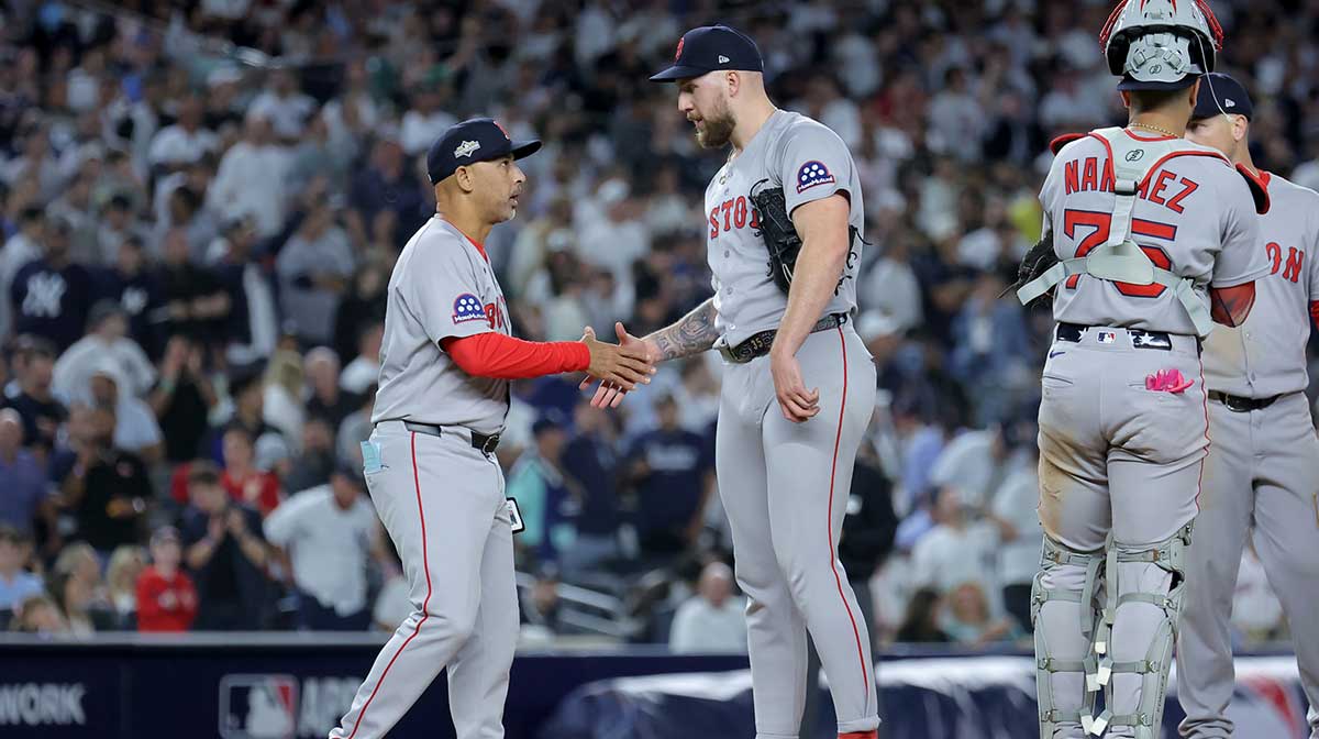 Boston Red Sox manager Alex Cora (13) shakes hands with starting pitcher Garrett Crochet (35) during a pitching change during the eighth inning of game one of the Wildcard round of the 2025 MLB playoffs against the New York Yankees at Yankee Stadium.