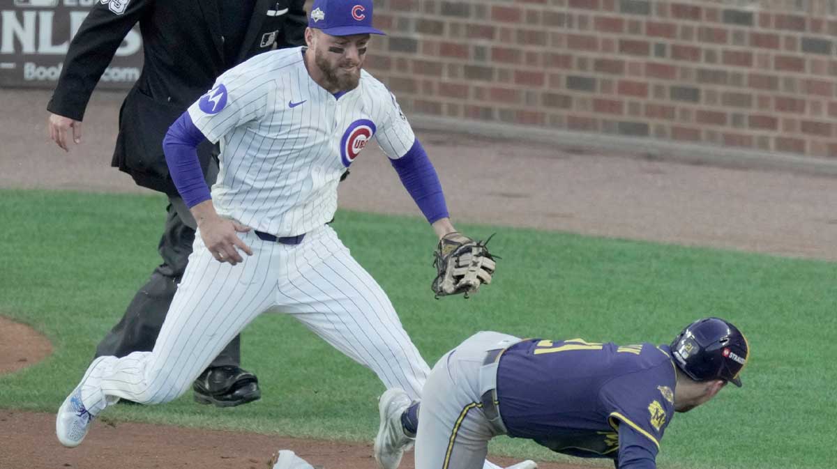 Milwaukee Brewers third baseman Caleb Durbin (21) is tagged out in rundown between third and home by Chicago Cubs first baseman Michael Busch (29) during the fourth inning of their National League Division Series game against the Chicago Cubs Wednesday, October 8, 2025 at Wrigley Field in Chicago, Illinois.