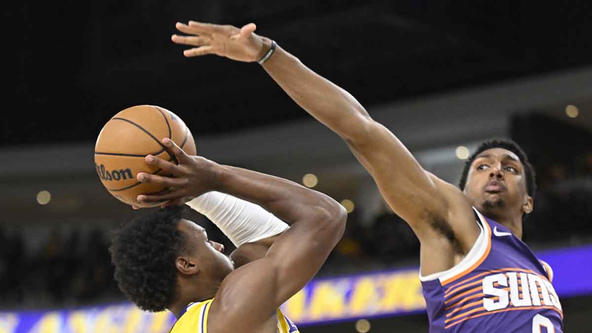 Los Angeles Lakers guard Bronny James (9) tries to shoot past Phoenix Suns forward Ryan Dunn (0) during the first half at Acrisure Arena.